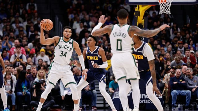 Milwaukee Bucks forward Giannis Antetokounmpo (34) catches a pass from guard Damian Lillard (0) as Denver Nuggets forward Peyton Watson (8) and guard Kentavious Caldwell-Pope (5) defend